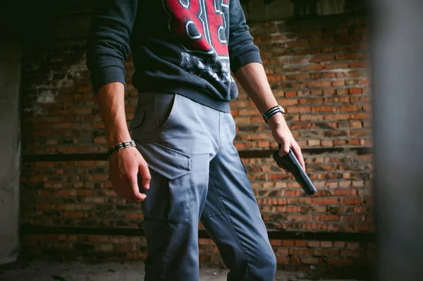 Hombre atlético en un pasamontañas, sostiene una pistola en su mano, es amenazado con disparar, apuntando — Foto de Stock