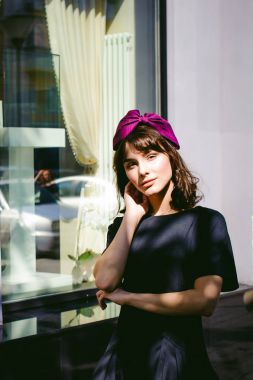 Karanlık bir şık elbiseli güzel kadın butikler yakınındaki cadde boyunca elini kolunu sallaya dönüyor. Bir moda kız portresi