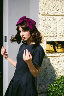 Karanlık bir şık elbiseli güzel kadın butikler yakınındaki cadde boyunca elini kolunu sallaya dönüyor. Bir moda kız portresi