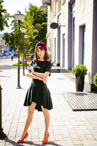Красивая женщина в темном стильном платье прогуливается по улице, возле бутиков. Портрет модной девушки — стоковое фото