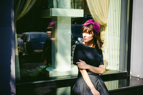 Schöne Frau in dunklem, stylischem Kleid schlendert die Straße entlang, in der Nähe von Boutiquen. Porträt eines modischen Mädchens — Stockfoto