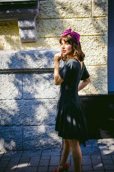 Hermosa mujer en un vestido elegante oscuro pasea por la calle, cerca de las boutiques. Retrato de una chica de moda — Foto de Stock