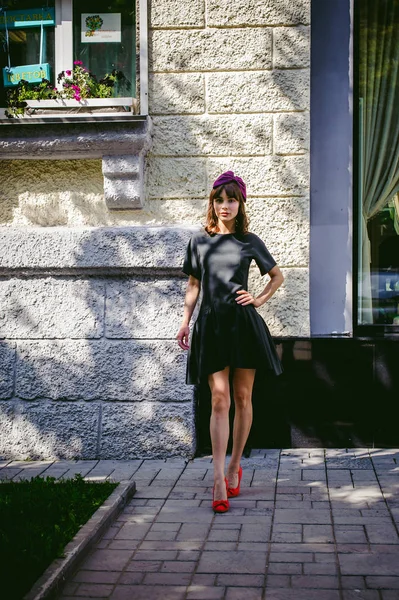 Schöne Frau in dunklem, stylischem Kleid schlendert die Straße entlang, in der Nähe von Boutiquen. Porträt eines modischen Mädchens — Stockfoto