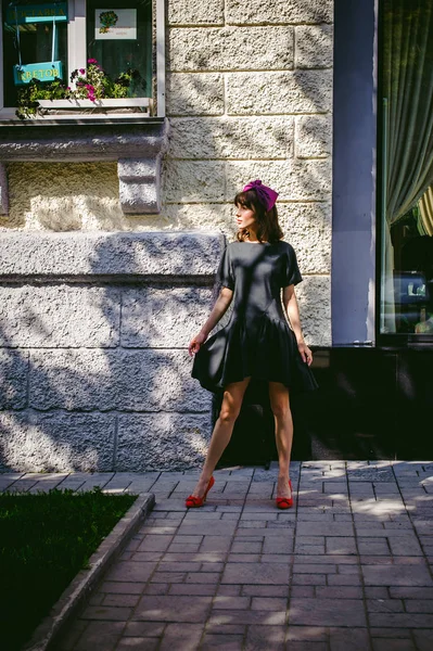 Schöne Frau in dunklem, stylischem Kleid schlendert die Straße entlang, in der Nähe von Boutiquen. Porträt eines modischen Mädchens — Stockfoto