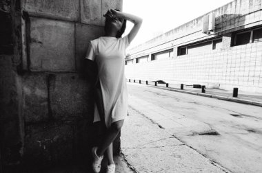 çıplak bacaklar beyaz spor ayakkabı ve cityscapes zemin karşı uzun bir T-shirt giymiş olan kadın