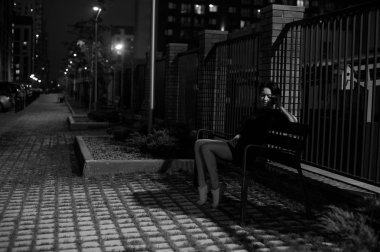 beyaz spor ayakkabı ve kentsel manzara fonunda siyah elbise giymiş güzel ayaklı genç kadın