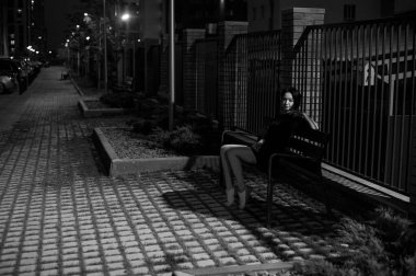 beyaz spor ayakkabı ve kentsel manzara fonunda siyah elbise giymiş güzel ayaklı genç kadın