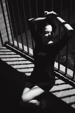 genç kadın güzel ayaklı beyaz spor ayakkabı ve kentsel manzara fonunda siyah elbise giymiş. Sokak moda. gece karanlık tarzı