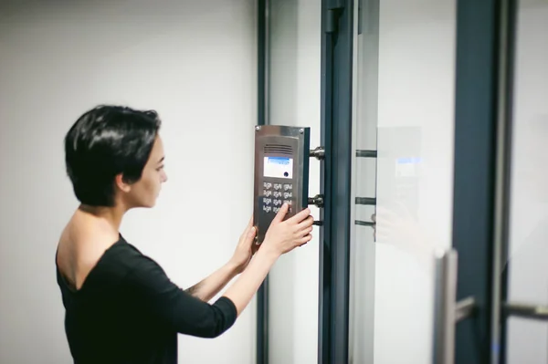 Woman is calling on the intercom — Stock Photo, Image