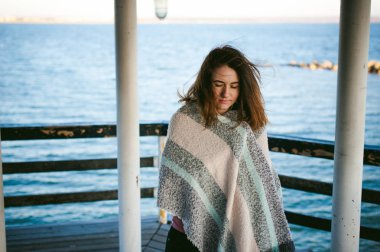 soğuk bir günde bir eşarp sahilde sarılı kadın