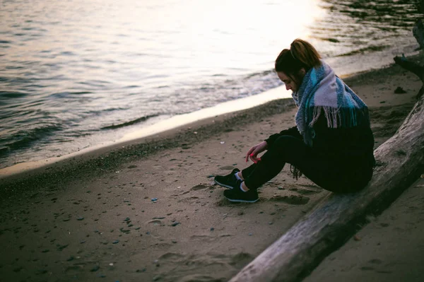 kadın sarılı bir eşarp sahilde günbatımı sonbahar soğuk bir günde