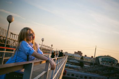 sevimli genç bir sarışın kadın bir yaz günü bir tren istasyonu çerçevede portresi