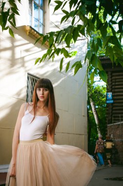 Caddenin bir sıcak güneşli yaz günü yürüyen genç güzel kadın