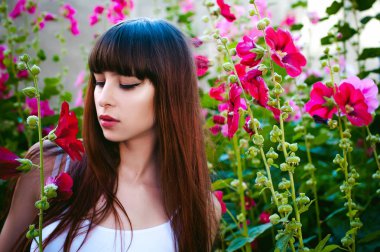 Caddenin bir sıcak güneşli yaz günü, portre çiçekler ile yürüyen genç güzel kadın