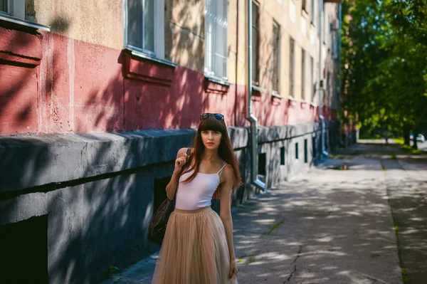 Caddenin bir sıcak güneşli yaz günü yürüyen genç güzel kadın