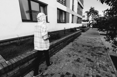 Kapüşonlu, açık renk ceketli, sakallı genç adam şehirde özgürce dolaşıyor.