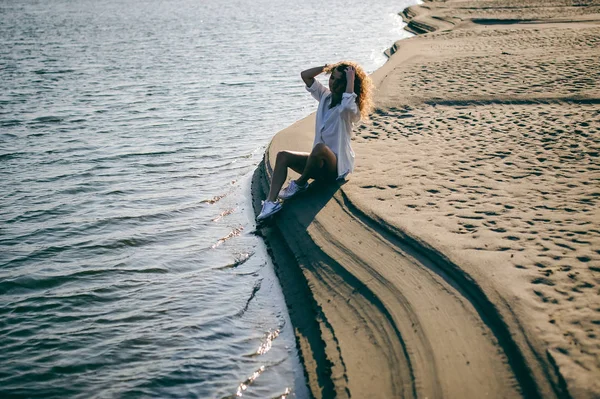 可爱的年轻女子卷曲的头发 青春的浪漫 一个旅程漫步在一个温暖的夏日阳光明媚的一天在沙滩上的水 — 图库照片