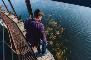 sakallı bir genç adam. Göl, terk edilmiş bir eski Barajı, sıcak güneşli bir gün için bir gezi