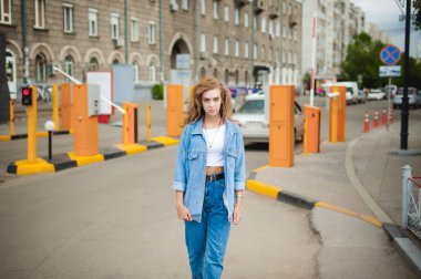 sokak kıvırcık paket fişi ile genç bir çekici duygusal kız portresi açık havada yürüyüş tarzı bir modaya uygun kot takım elbise giymiş