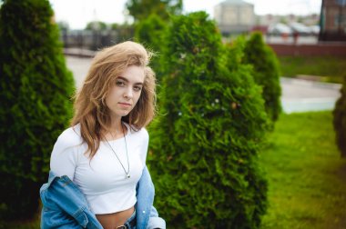 sokak kıvırcık paket fişi ile genç bir çekici duygusal kız portresi açık havada yürüyüş tarzı bir trendy mavi kot takım elbise giymiş. kameraya bak