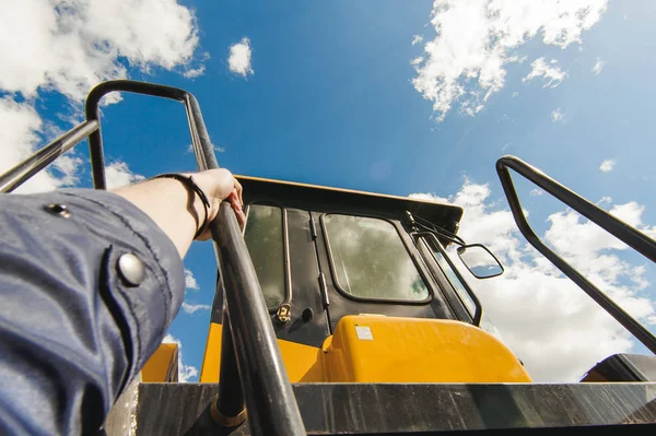 cabin front loader on a background of blue sky, steps on a tractor