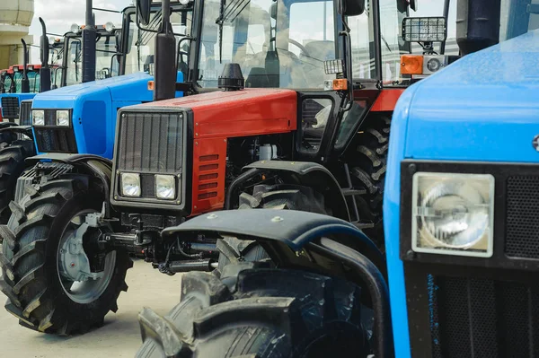 Jordbruksmaskiner Traktorer Står Rad Med Blå Och Röd Nya Maskiner — Stockfoto