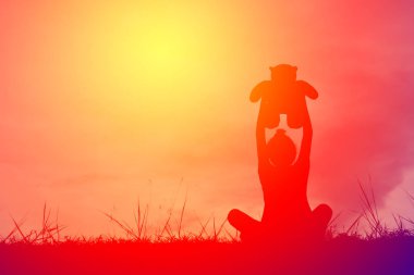 Siluet oyuncak ayı dağ ve gökyüzü günbatımı, mutlu kız tatil süreci tarzı vintage tonda bir kızla