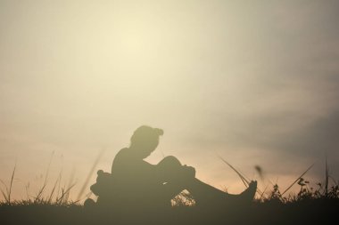 Siluet oyuncak ayı dağ ve gökyüzü günbatımı, mutlu kız tatil süreci tarzı vintage tonda bir kızla