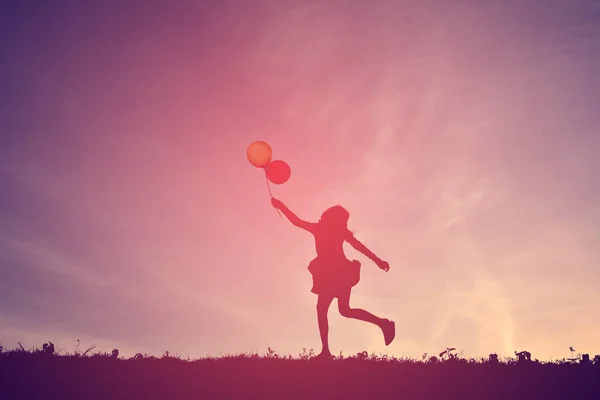 Silhouette eines Mädchens mit Ballon bei Sonnenuntergang — Stockfoto