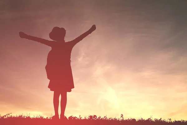 Silhueta uma menina brincando ao pôr do sol — Fotografia de Stock