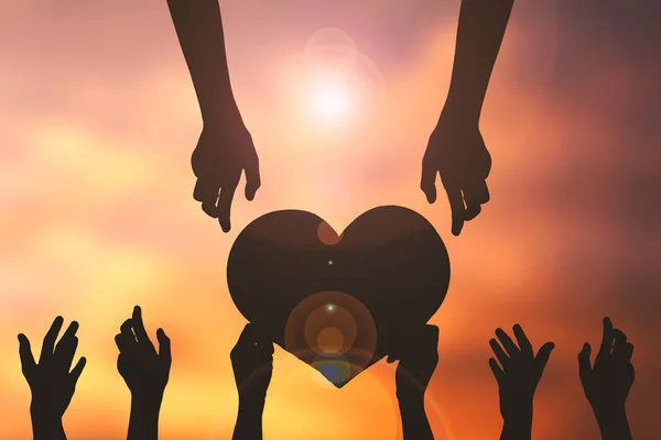 Silhouette hand holding heart shape sunset background. concept love — Stock Photo, Image