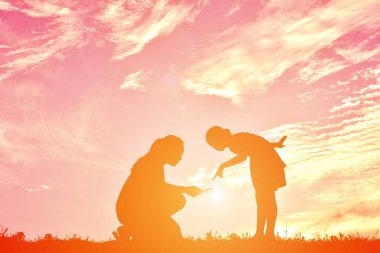 siluetleri anne ve gün batımında oynayan kız