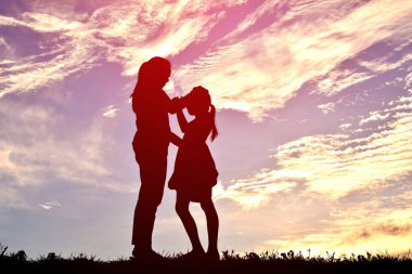 siluetleri anne ve gün batımında oynayan kız