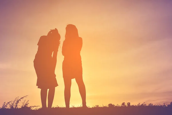 Silhouette femmes sur le ciel coucher de soleil — Photo