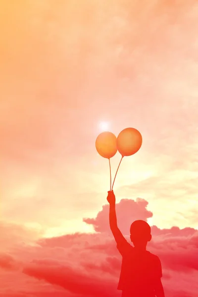 Silhouette Kinder mit Luftballon bei Sonnenuntergang — Stockfoto