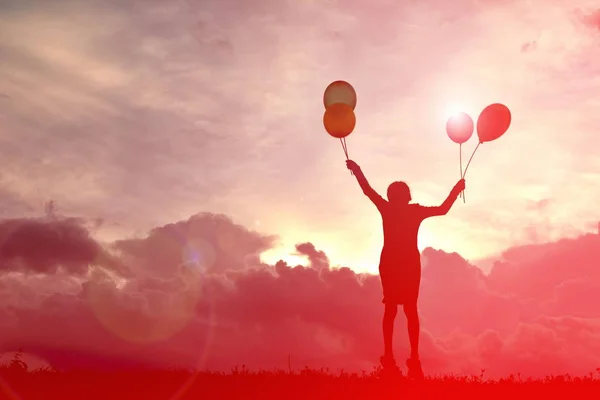 Silhouette barn med ballong vid solnedgången — Stockfoto