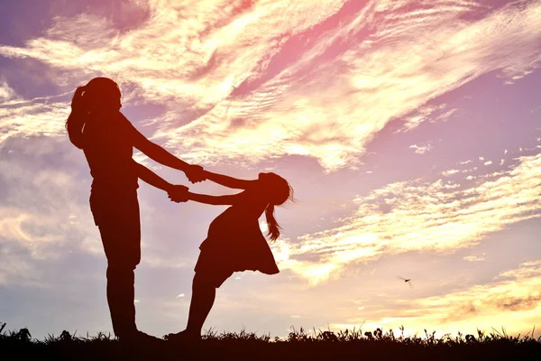 Silhouetten glückliche Familie spielt bei Sonnenuntergang. Konzept Muttertag — Stockfoto