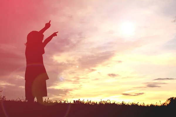 Silhouette glad liten flicka vid solnedgången — Stockfoto