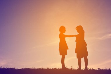 Siluet çocuklar günbatımı üzerinde oyun