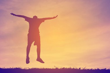 Gün batımında atlama siluet mutlu çocuk