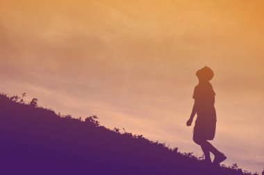 Günbatımı üzerinde çalışan bir çocuk siluet