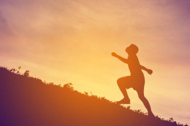 Günbatımı üzerinde çalışan bir çocuk siluet