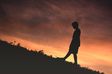 Siluet bir çocuk sakin ol günbatımı üzerinde