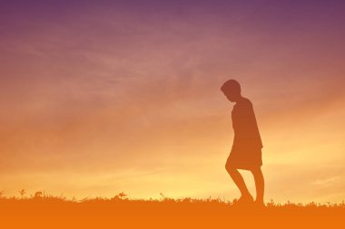 Siluet bir çocuk sakin ol günbatımı üzerinde