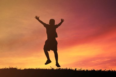 Siluet bir çocuk sakin ol günbatımı üzerinde