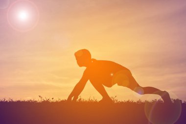 Günbatımı üzerinde çalışan bir çocuk siluet