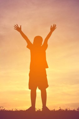 Siluet bir çocuk sakin ol günbatımı üzerinde