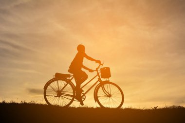 Günbatımı bisikletli çocukla siluet