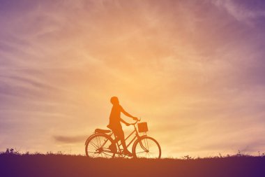 Günbatımı bisikletli çocukla siluet