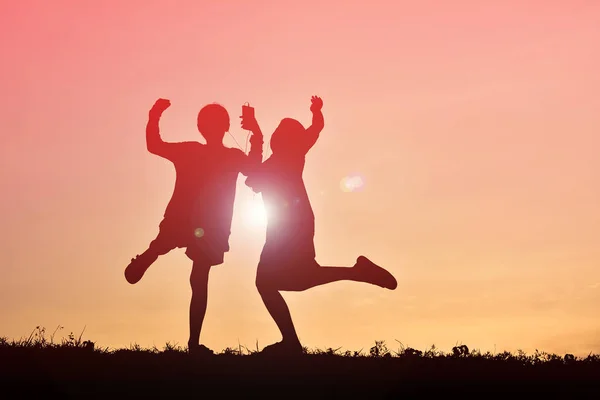 Silhouette Kinder mit Smartphone bei Sonnenuntergang — Stockfoto